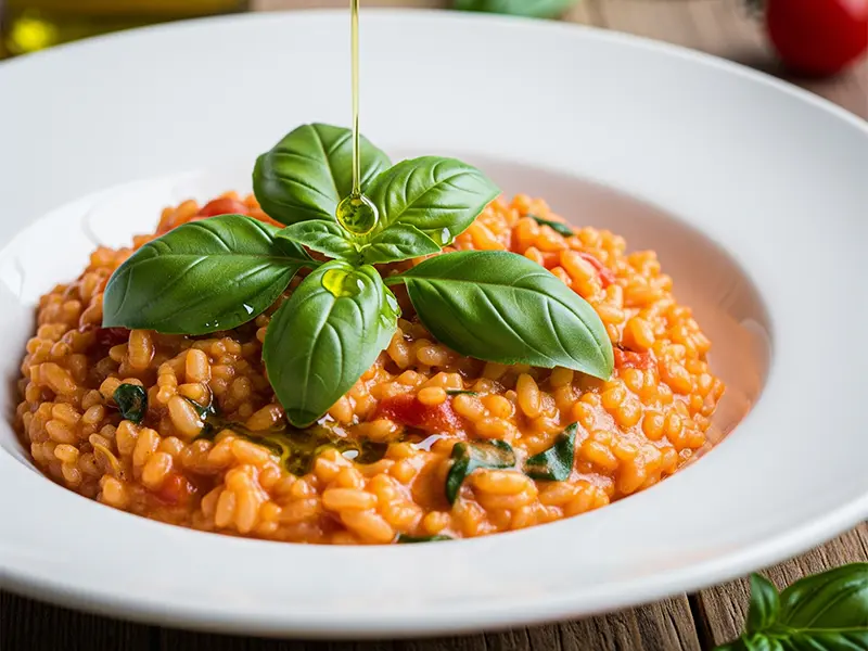 Assiette de risotto à la tomate crémeux, garni de basilic frais